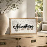 Adventure Is Out There balloon house framed wood sign styled on a light oak console in a sunlit conservatory