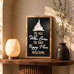 To All Who Come To This Happy Place Welcome dedication plaque framed wood sign styled in a golden hour vestibule