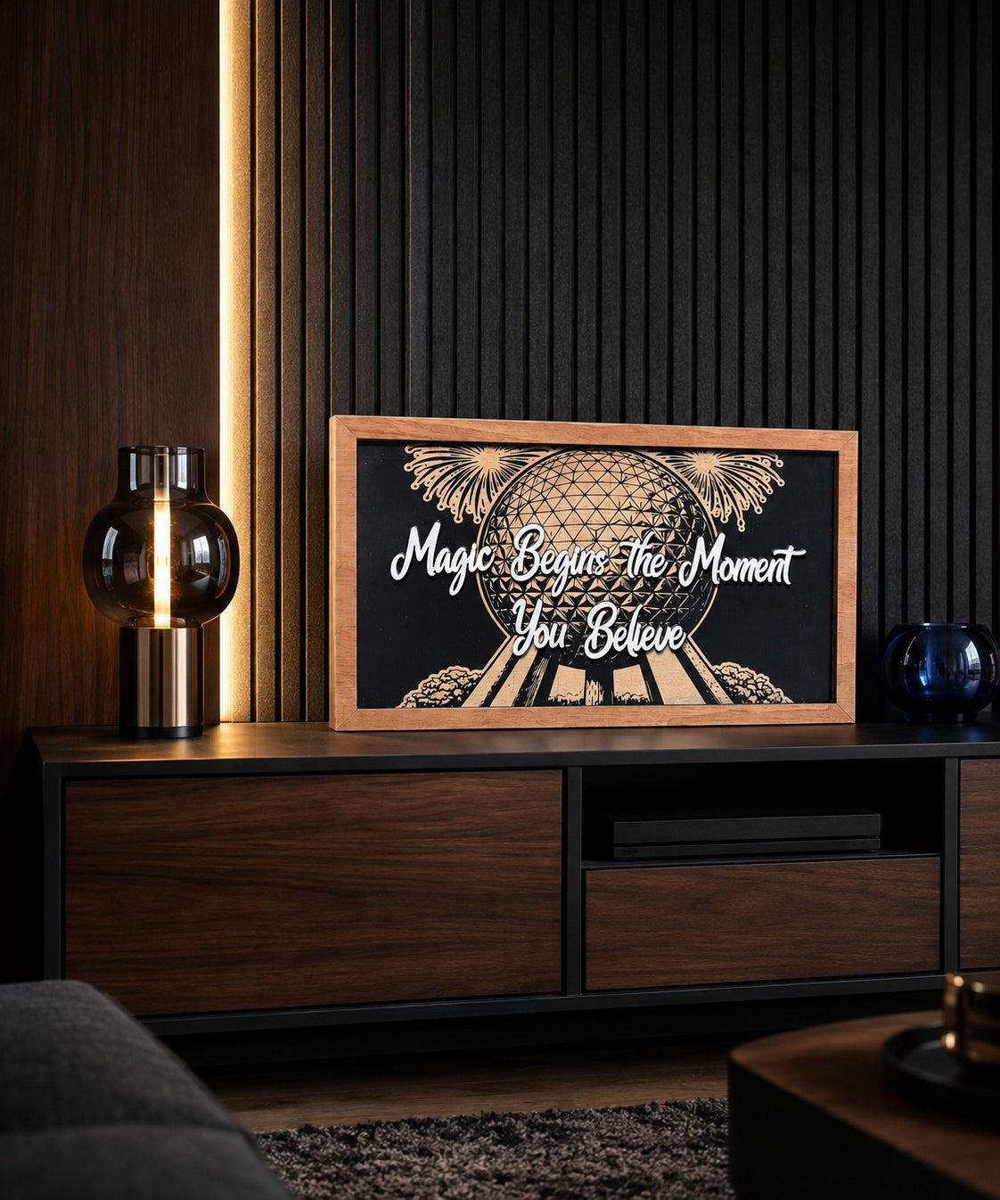 Magic Begins The Moment You Believe geodesic sphere framed wood sign styled on a walnut media console