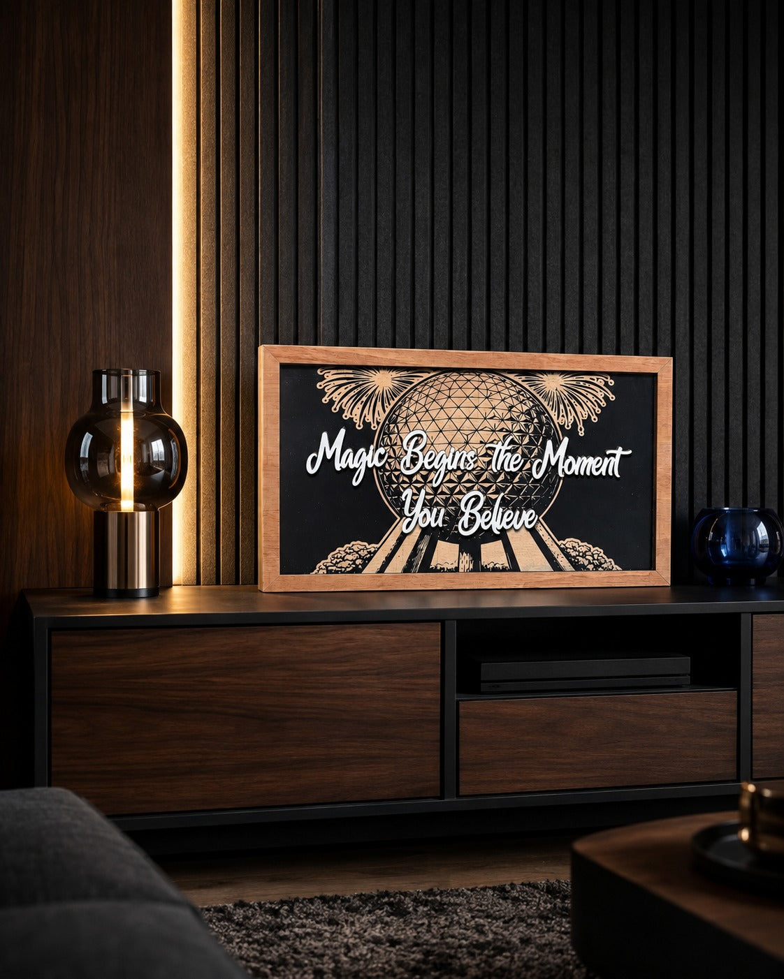 Magic Begins The Moment You Believe geodesic sphere framed wood sign styled on a walnut media console