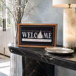 Welcome Main Street USA castle icon framed wood sign styled on a marble console in a luxury foyer