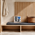 HOME square framed wood sign with blue mouse head icon styled on a pale oak mudroom bench
