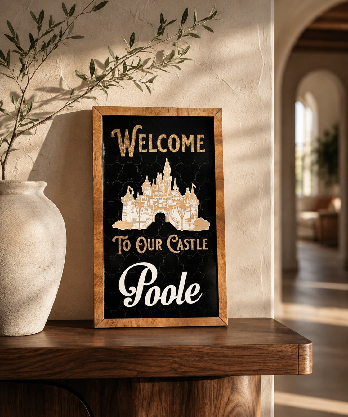 Welcome To Our Castle personalized framed wood sign styled on a walnut shelf in a warm foyer