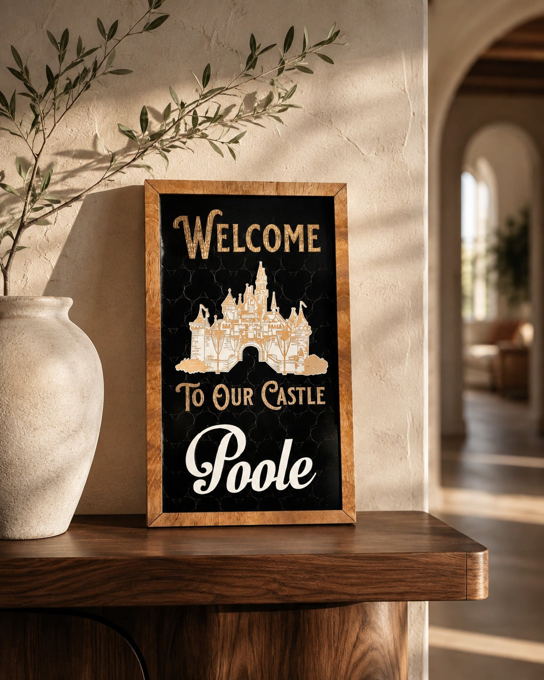 Welcome To Our Castle personalized framed wood sign styled on a walnut shelf in a warm foyer