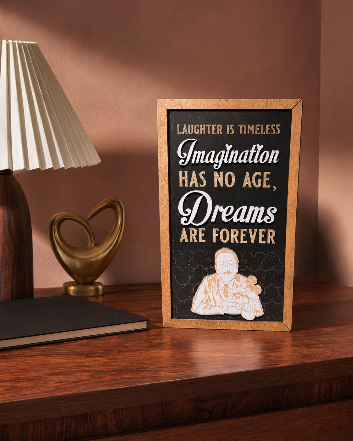 Laughter Is Timeless Imagination Has No Age framed wood sign styled in a rosewood reading room