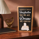 Laughter Is Timeless Imagination Has No Age framed wood sign styled in a rosewood reading room