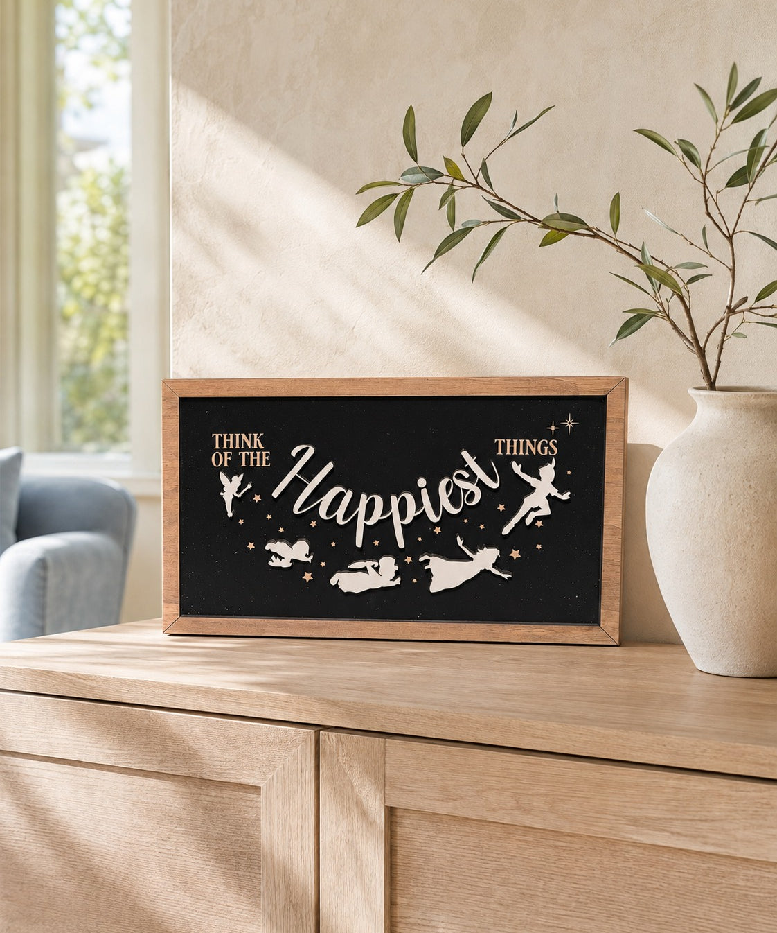 Think Of The Happiest Things Neverland framed wood sign styled on a sunlit oak console