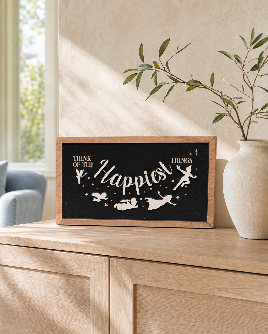 Think Of The Happiest Things Neverland framed wood sign styled on a sunlit oak console