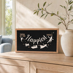 Think Of The Happiest Things Neverland framed wood sign styled on a sunlit oak console