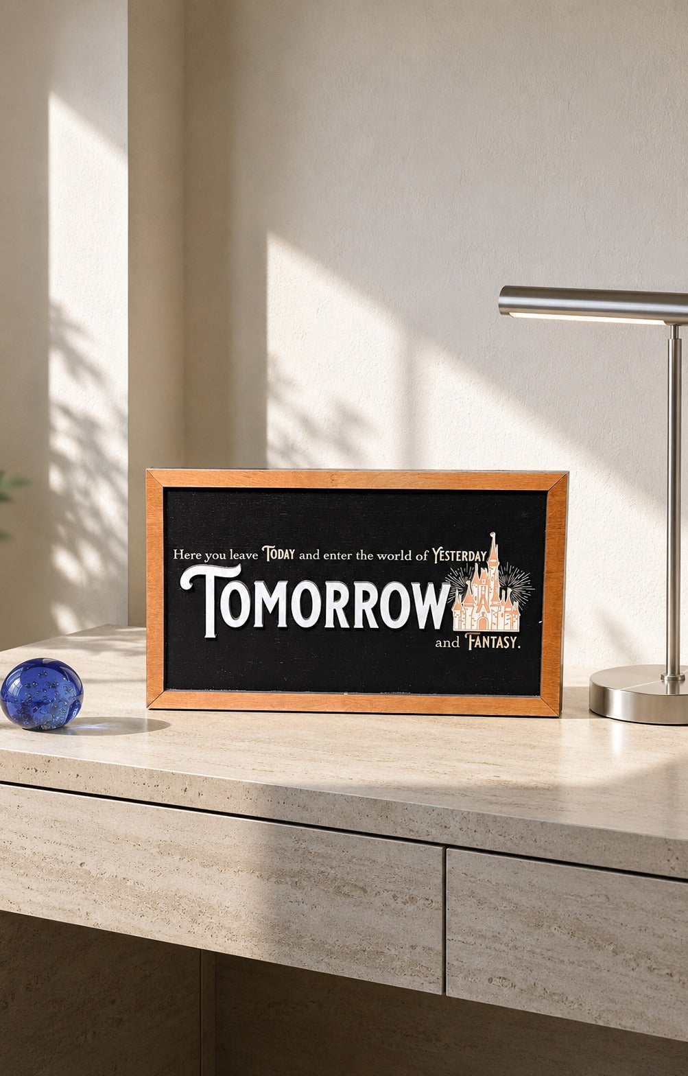 Here You Leave Today castle tribute framed wood sign styled on a sunlit travertine credenza