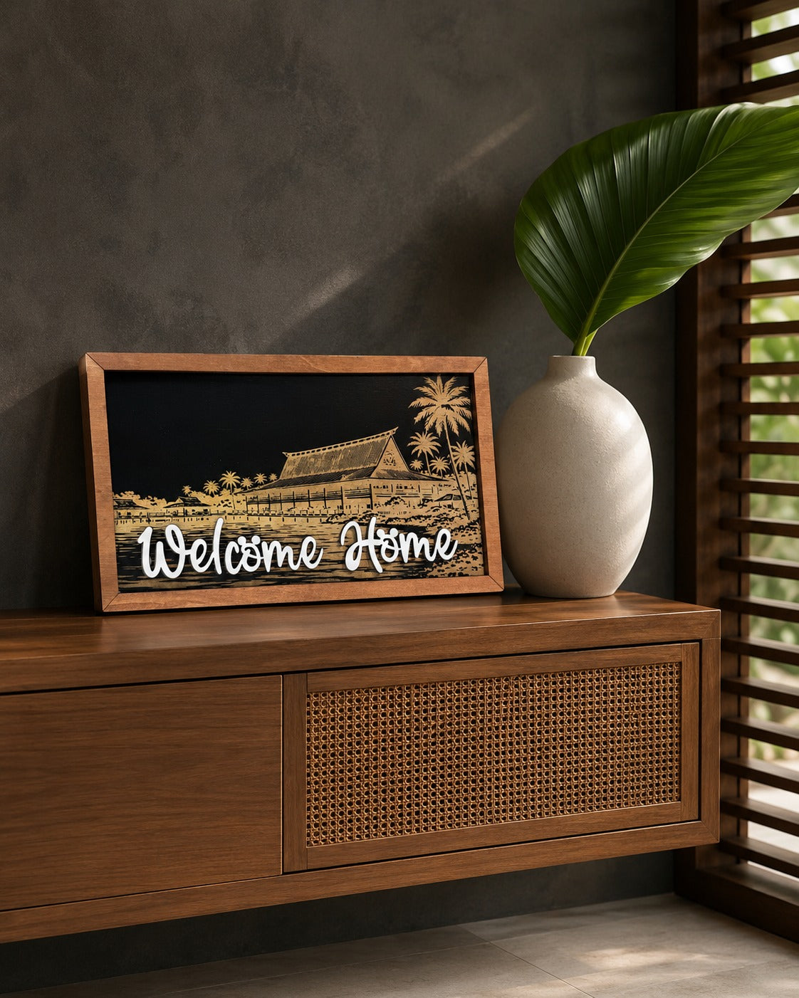 Welcome Home Polynesian island resort framed wood sign styled on a teak sideboard