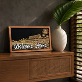 Welcome Home Polynesian island resort framed wood sign styled on a teak sideboard
