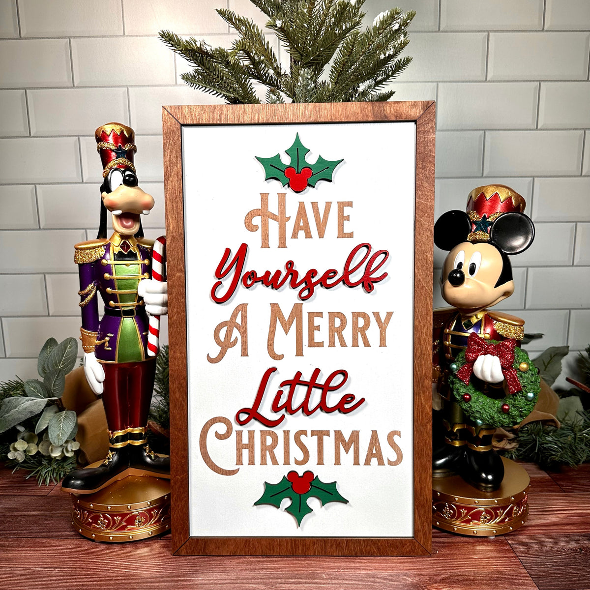 Framed Have Yourself a Merry Little Christmas sign displayed with character nutcrackers.