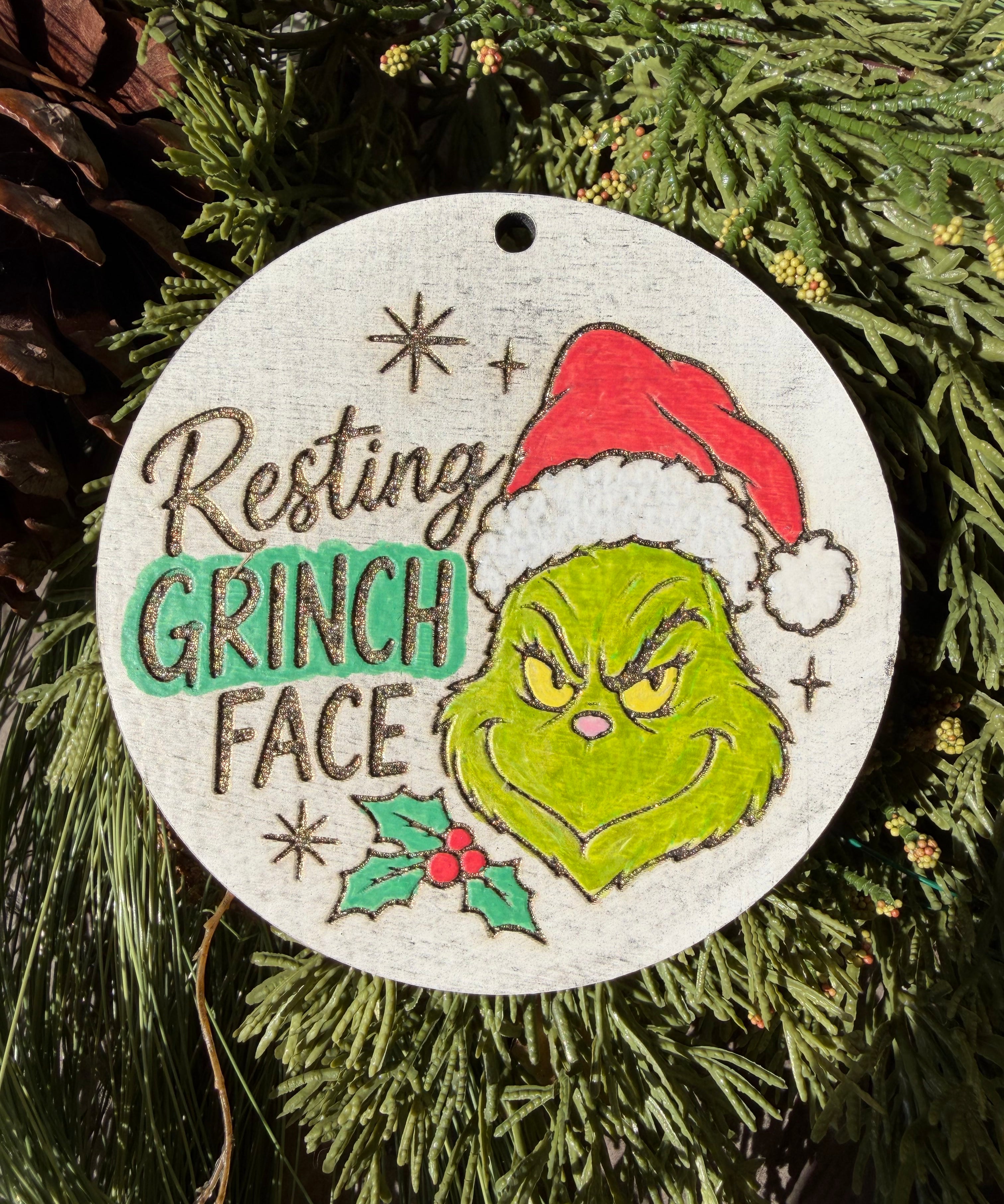 Finished hand-painted Resting Grinch Face on evergreen greenery.