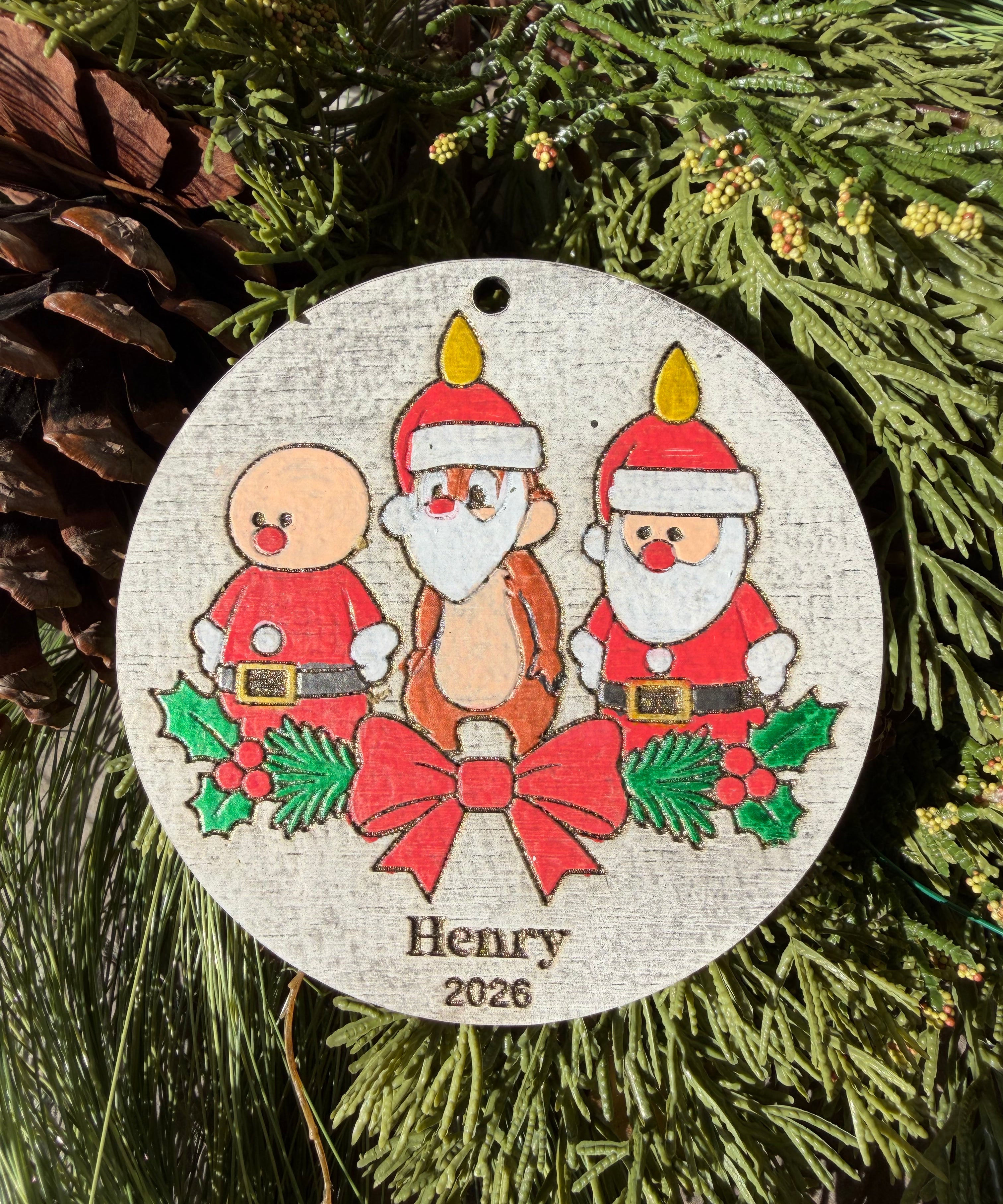 Finished hand-painted Dale’s Candlelight Christmas Ornament on evergreen greenery. Personal name and year shown are sample personalization.