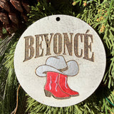 Finished hand-painted Beyoncé Cowboy Boots & Hat on evergreen greenery.