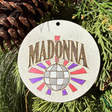 Finished hand-painted Madonna Disco Ball on evergreen greenery.