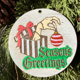 Finished hand-painted Season’s Greetings Striped Gift on evergreen greenery.
