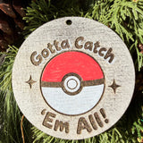 Finished hand-painted Gotta Catch ’Em All on evergreen greenery.