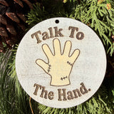 Finished hand-painted Talk to the Hand on evergreen greenery.
