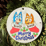 Finished hand-painted Bluey & Bingo Merry Christmas on evergreen greenery.