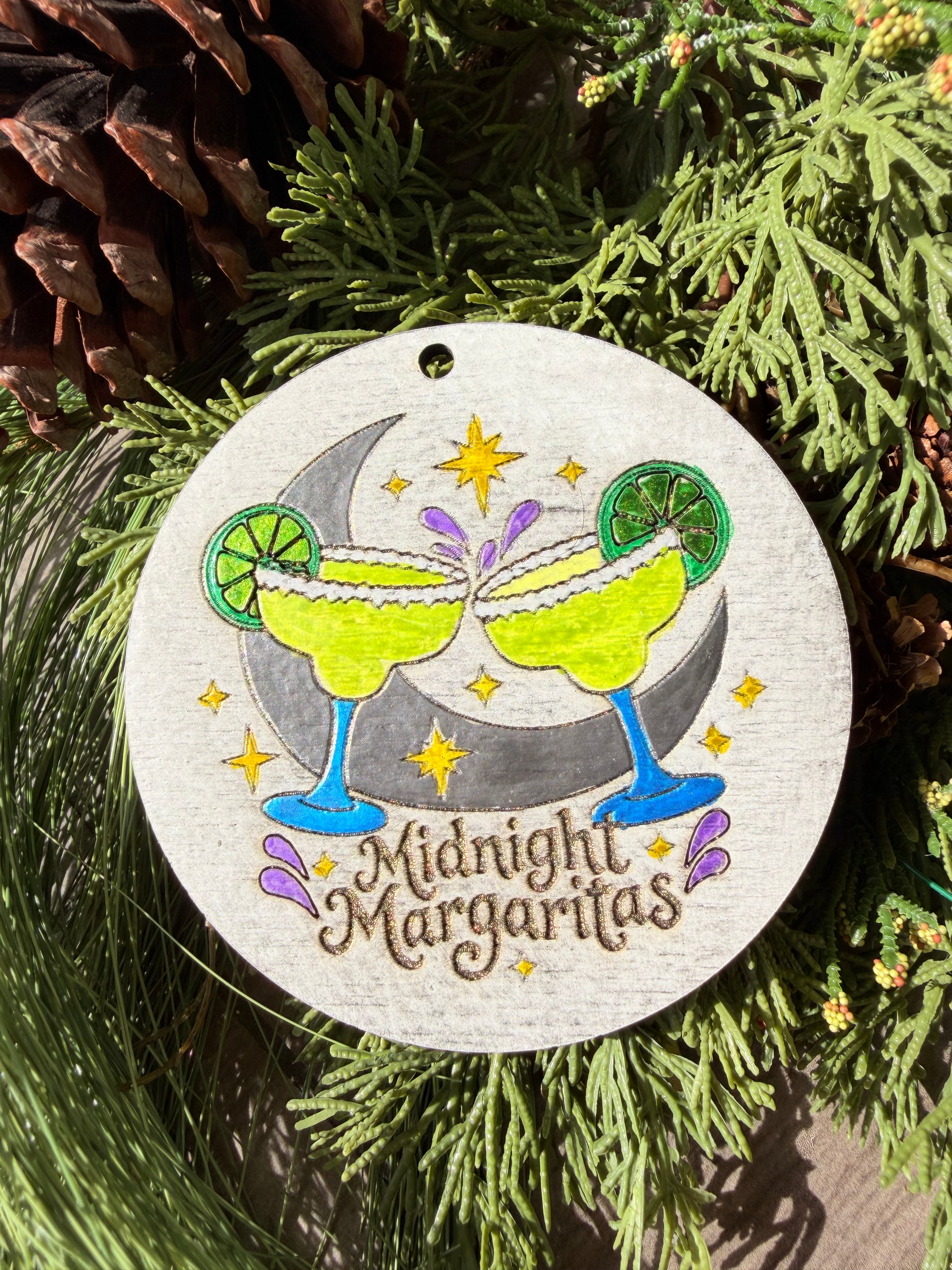 Finished hand-painted Midnight Margaritas on evergreen greenery.