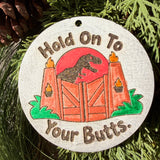 Finished hand-painted Hold On to Your Butts on evergreen greenery.