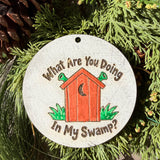 Finished hand-painted What Are You Doing in My Swamp? on evergreen greenery.