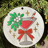Finished hand-painted Mistletoe Cocktail on evergreen greenery.