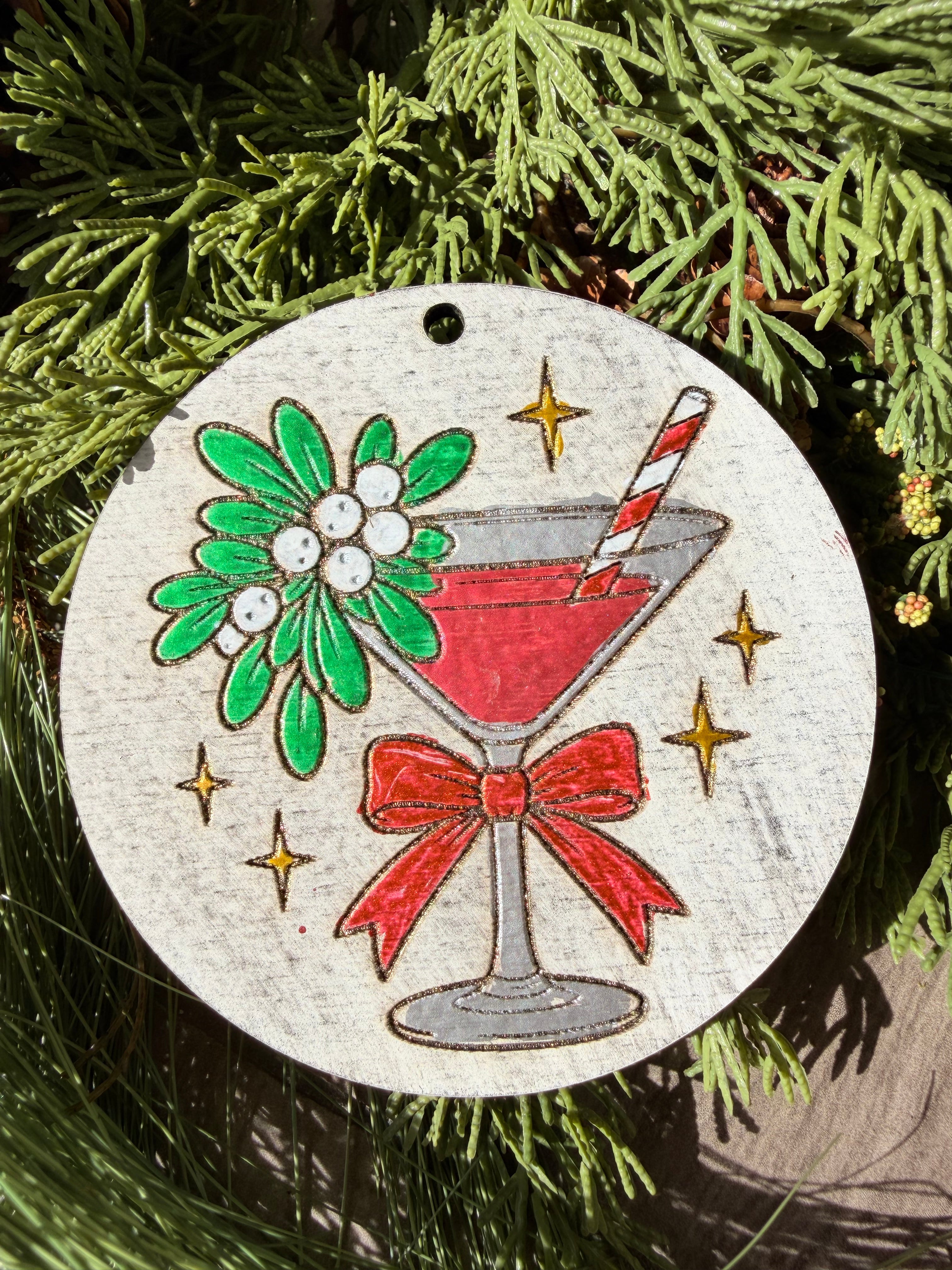 Finished hand-painted Mistletoe Cocktail on evergreen greenery.