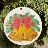 Finished hand-painted Golden Christmas Bells on evergreen greenery.