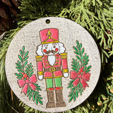 Finished hand-painted Pink & Green Nutcracker on evergreen greenery.