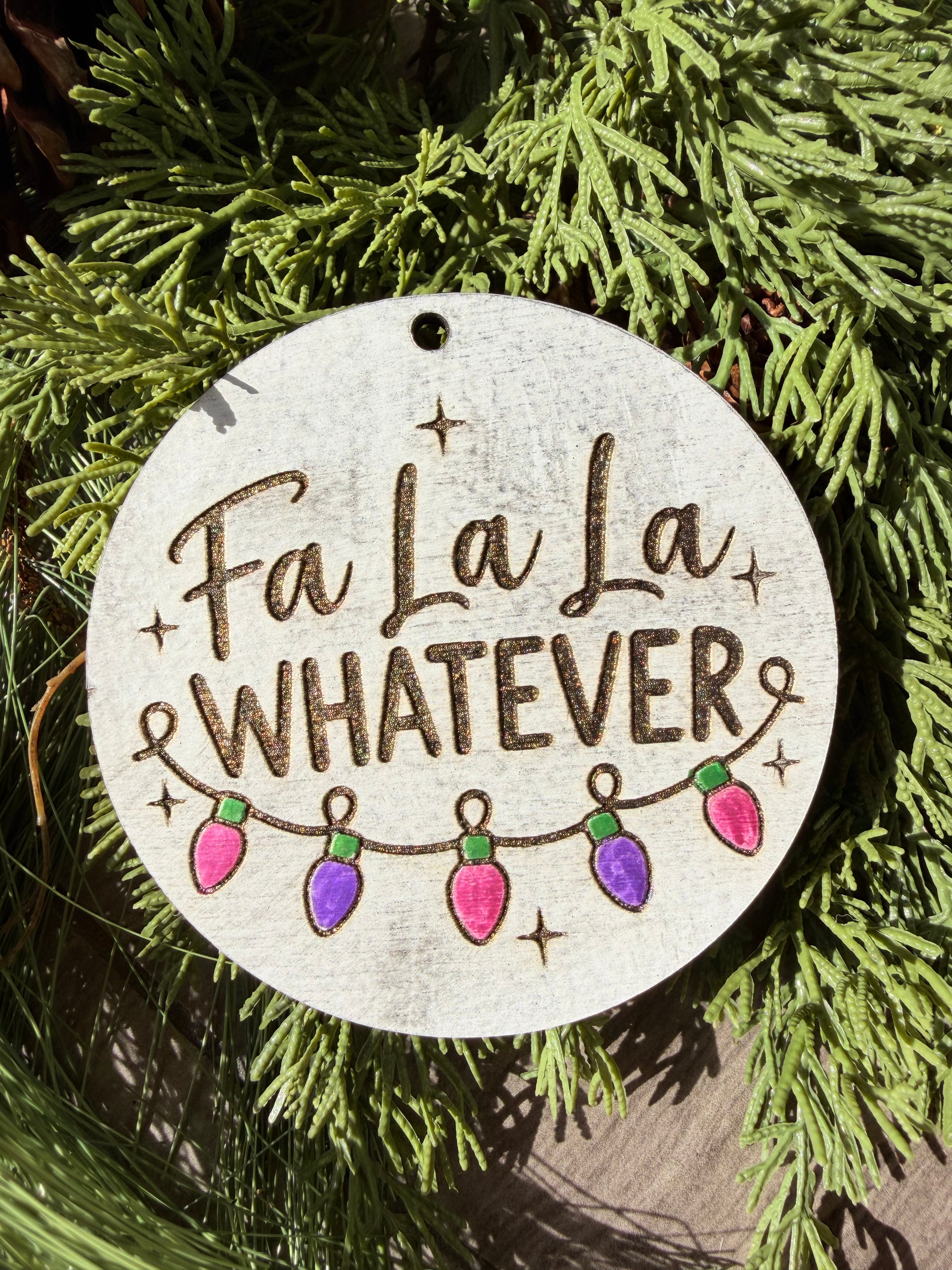 Finished hand-painted Fa La La Whatever on evergreen greenery.