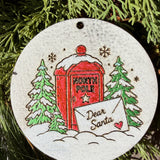 Finished hand-painted North Pole Mailbox on evergreen greenery.