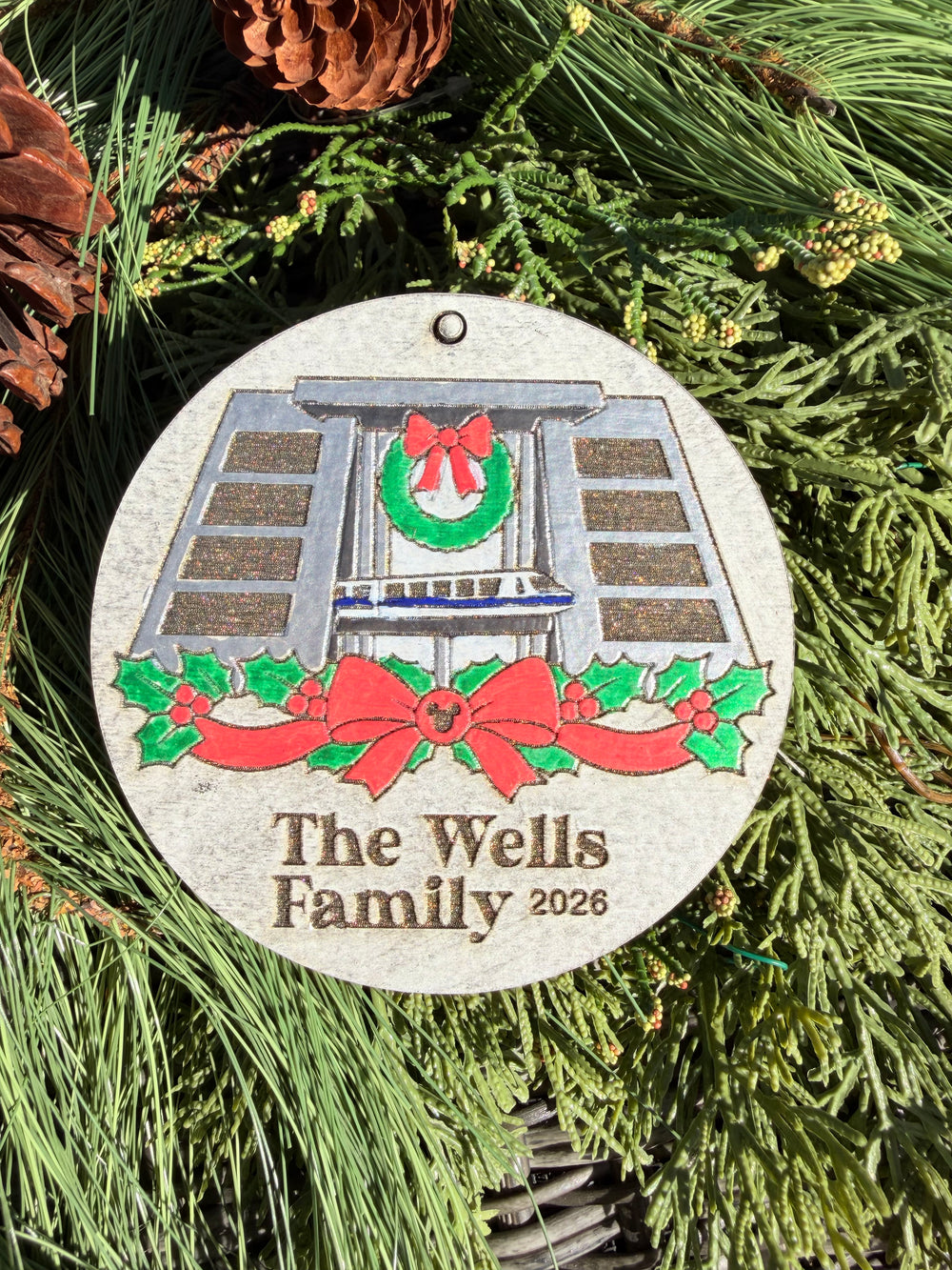 Finished hand-painted Contemporary Resort Christmas Ornament on evergreen greenery. Name and year shown are sample personalization.
