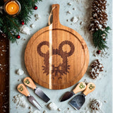 Round mouse pine wreath charcuterie board styled with four matching engraved utensils
