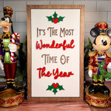 It's the Most Wonderful Time of the Year vertical Christmas sign with red lettering, green holly and a brown wood frame.
