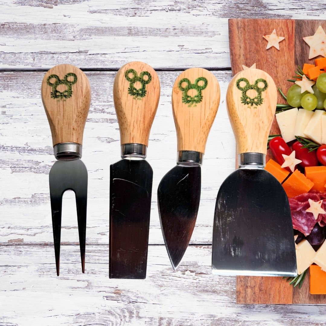 Four piece charcuterie utensil set with mouse pine wreath engravings on wooden handles
